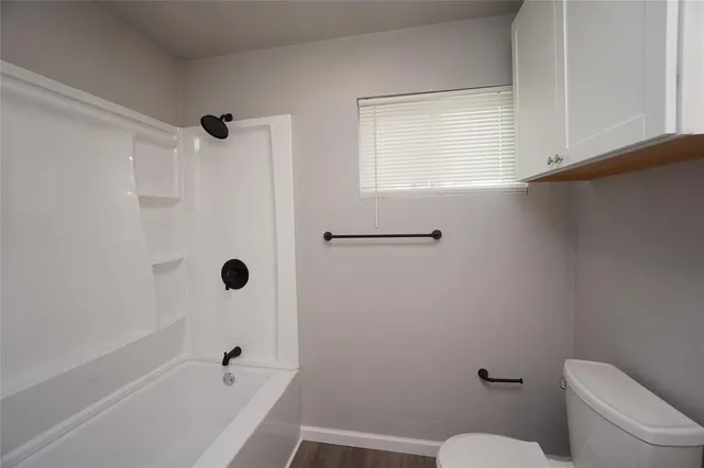 a white toilet sitting next to a bath tub