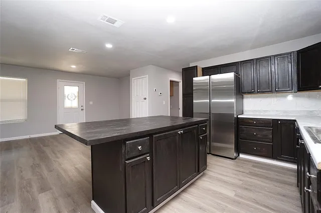 a kitchen with granite countertop cabinets appliances and wooden floor