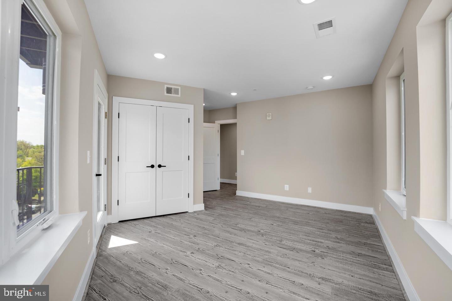 1617 Rhode Island Avenue Northeast, Unit 102 Washington, DC 20018 - Photo 11 of 17 a view of an empty room with wooden floor and a window