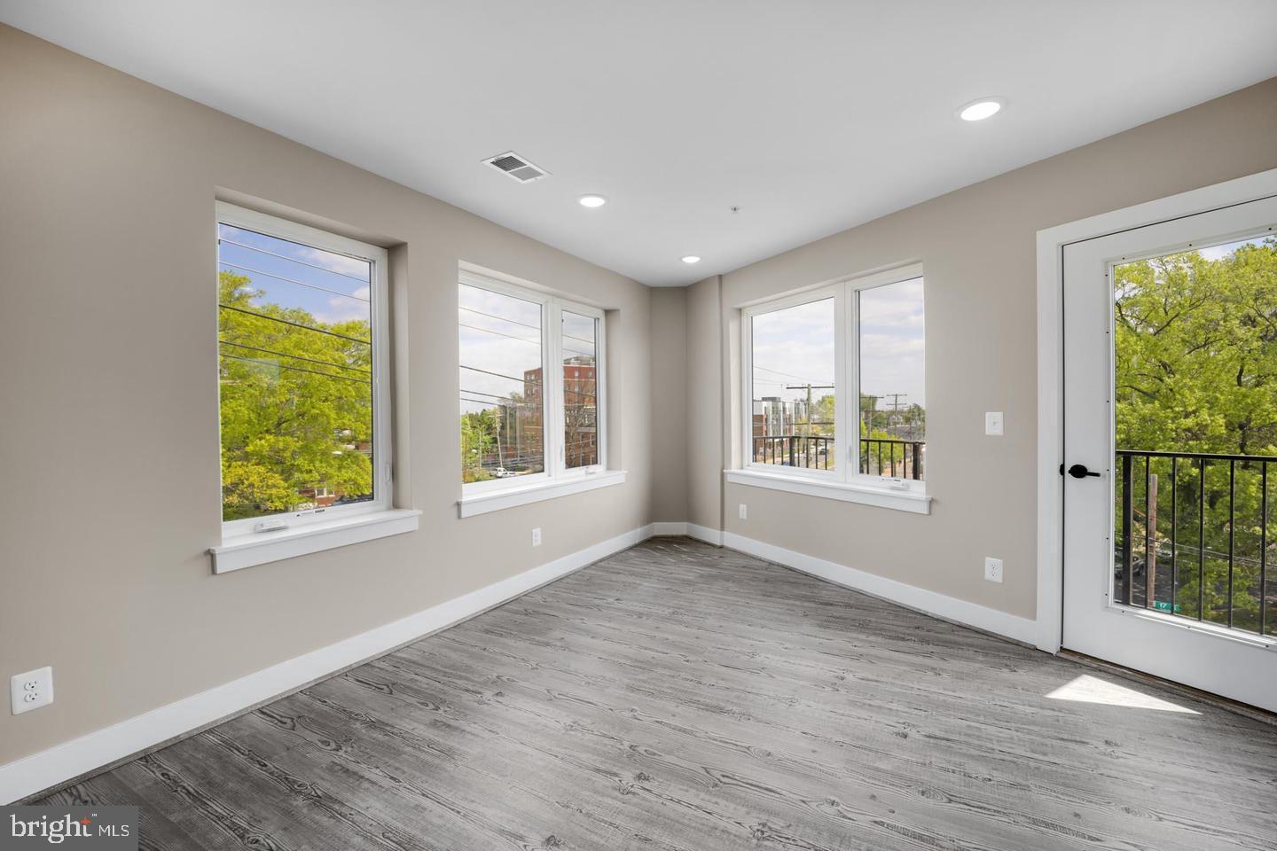 1617 Rhode Island Avenue Northeast, Unit 102 Washington, DC 20018 - Photo 7 of 17 a view of an empty room with wooden floor and a window