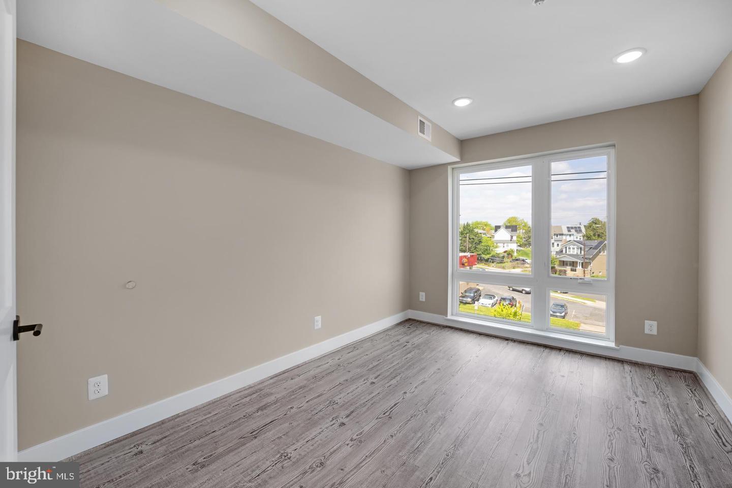 1617 Rhode Island Avenue Northeast, Unit 102 Washington, DC 20018 - Photo 10 of 17 wooden floor in an empty room with a window