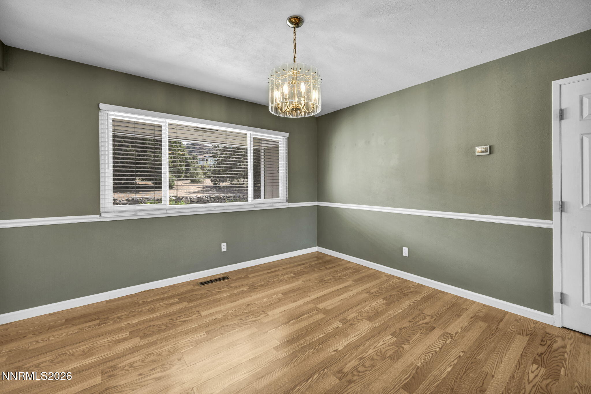 14190 Rim Rock Drive Reno, NV 89521 - Photo 17 of 68 a view of an empty room with window and wooden floor