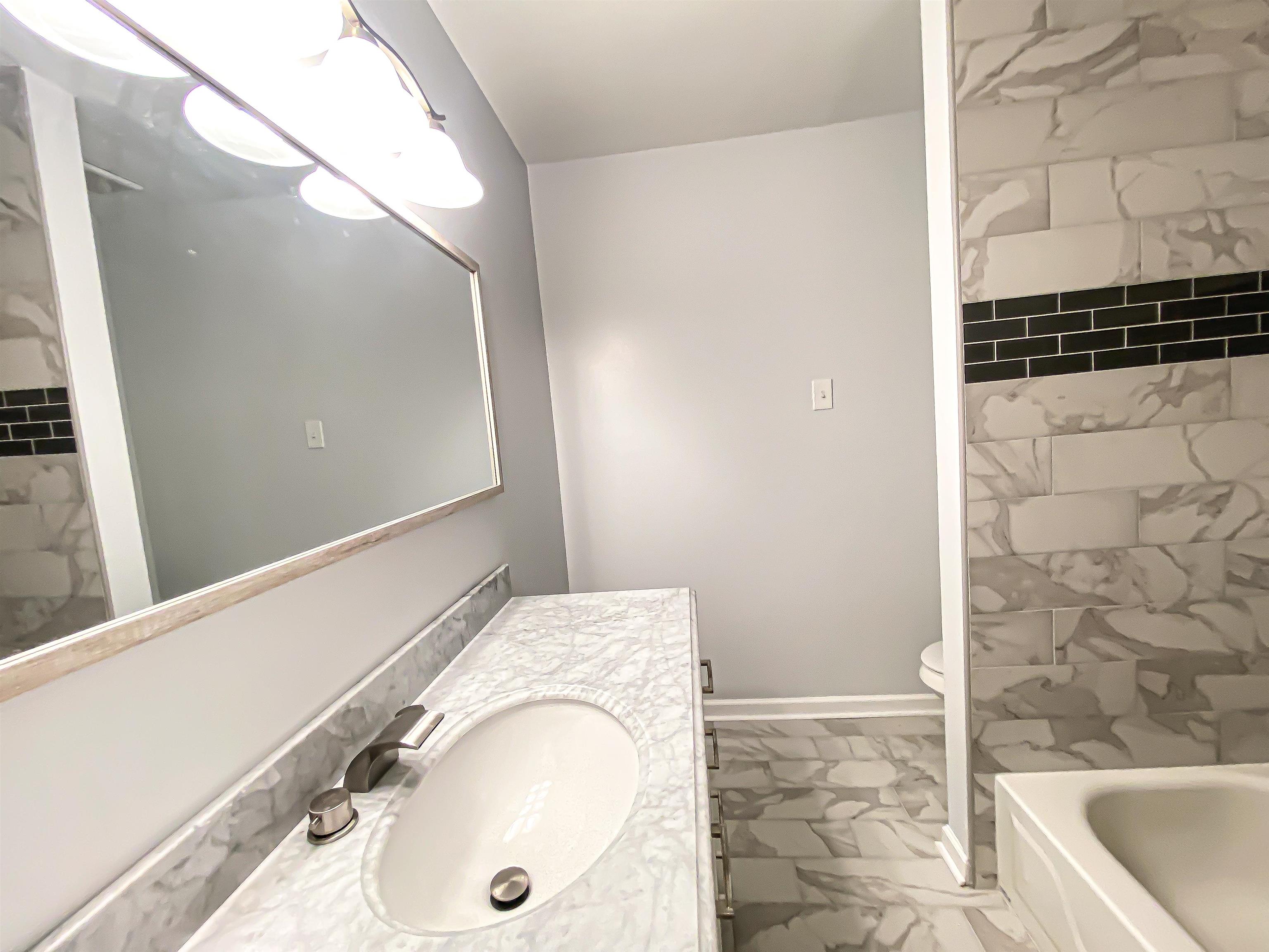 157 Pickett Road Memphis, TN 38109 - Photo 19 of 24 a bathroom with a granite countertop sink and a mirror