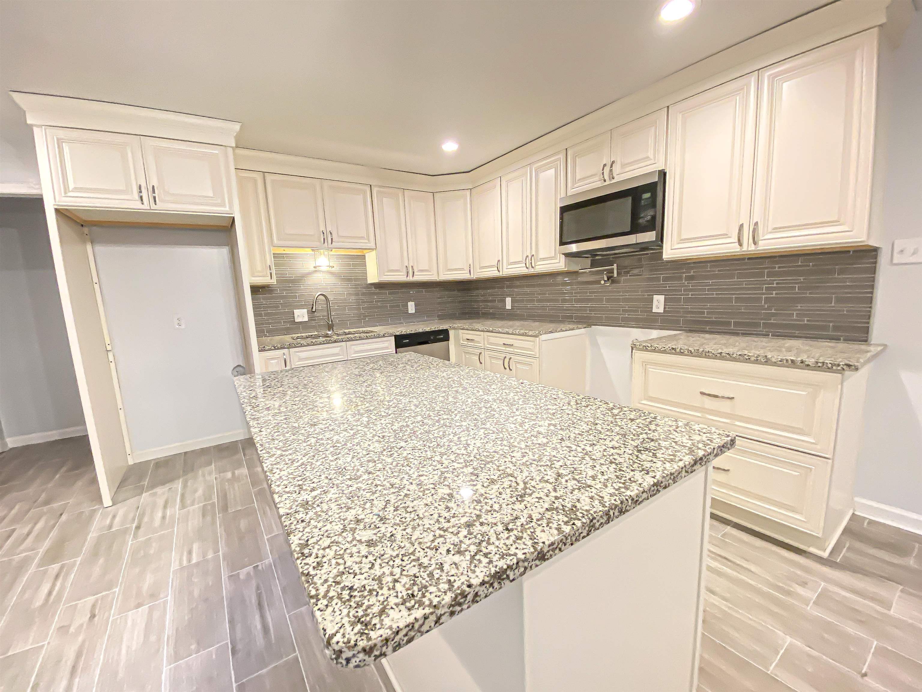 157 Pickett Road Memphis, TN 38109 - Photo 8 of 24 a kitchen with stainless steel appliances granite countertop a sink stove microwave and refrigerator