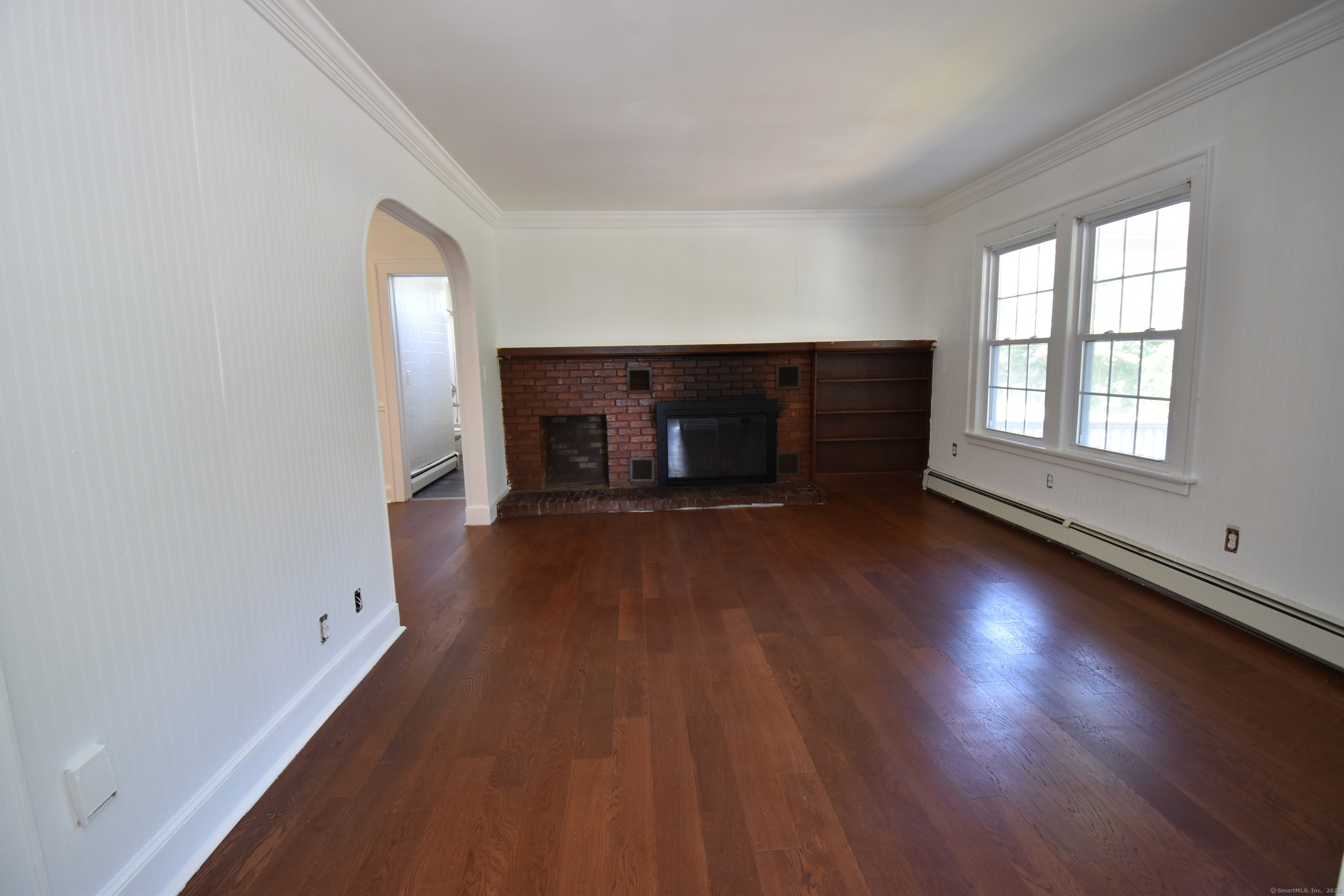 1197 Prospect Road Prospect, CT 06712 - Photo 5 of 21 an empty room with wooden floor fireplace and windows