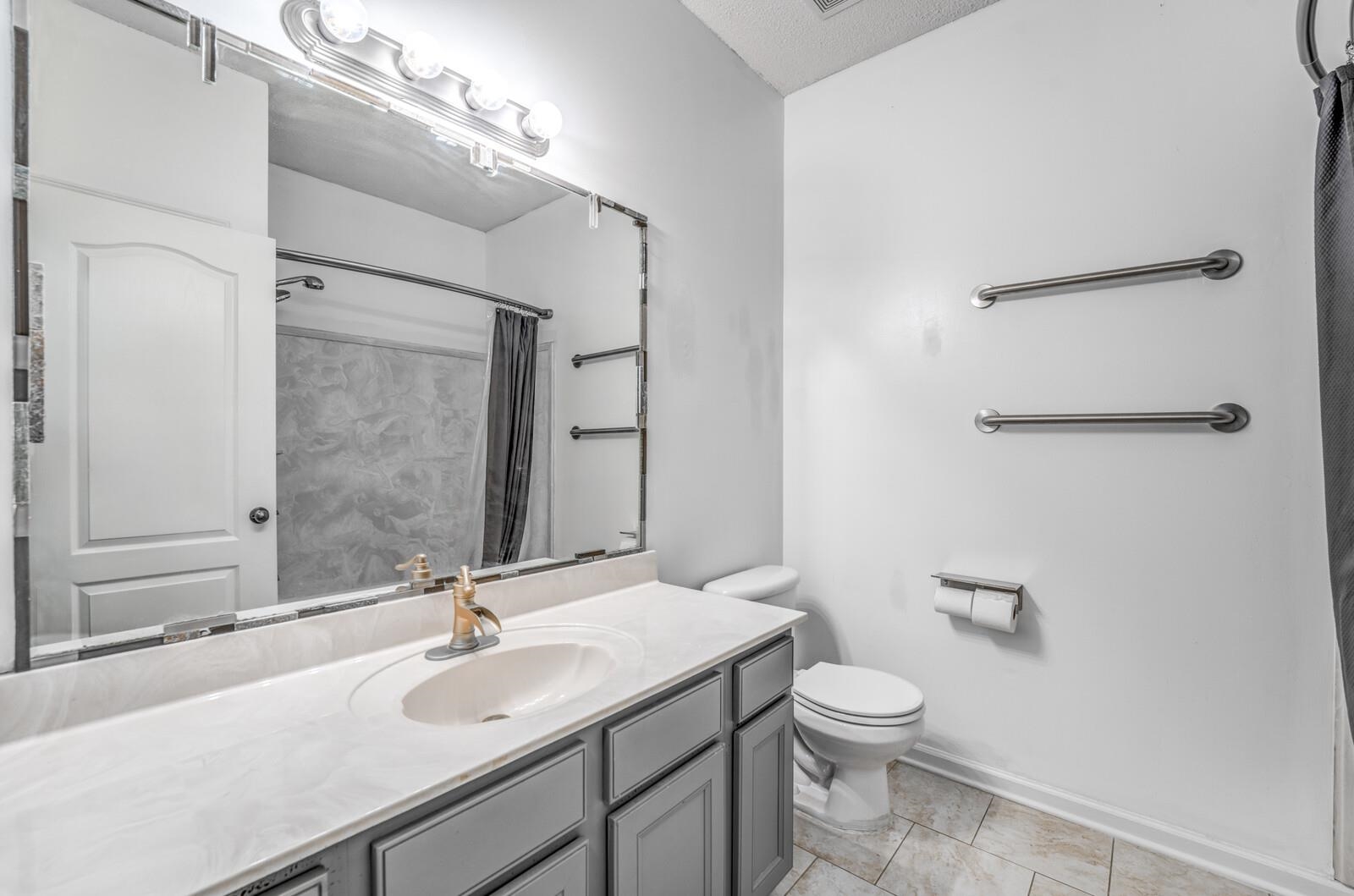 8574 Thor Road Memphis, TN 38018 - Photo 31 of 40 Bathroom with vanity, a shower with shower curtain, baseboards, tile patterned floors, and toilet