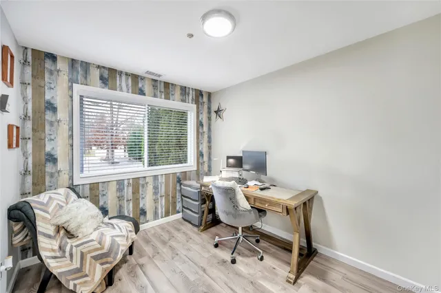 a view of a workspace with furniture and a window