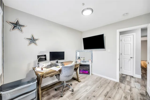 a view of a livingroom with workspace and a flat screen tv