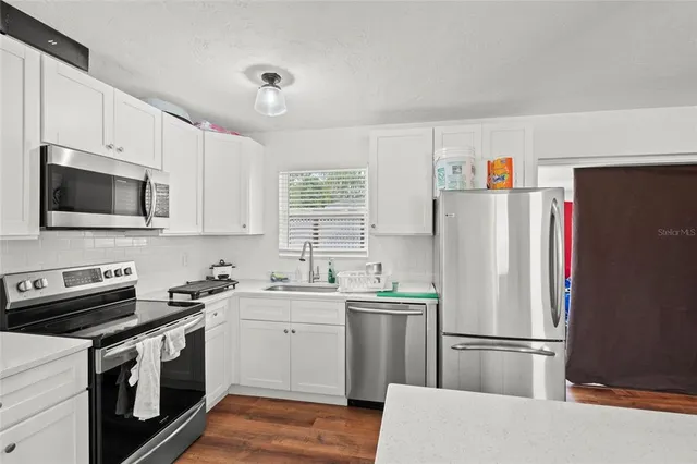 a kitchen with a sink a refrigerator a microwave and cabinets