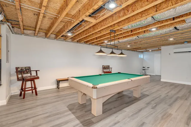 a roof deck with table and chairs with wooden floor