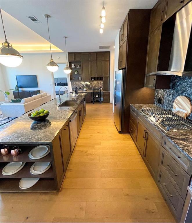 a kitchen with stainless steel appliances granite countertop a sink counter space and a stove