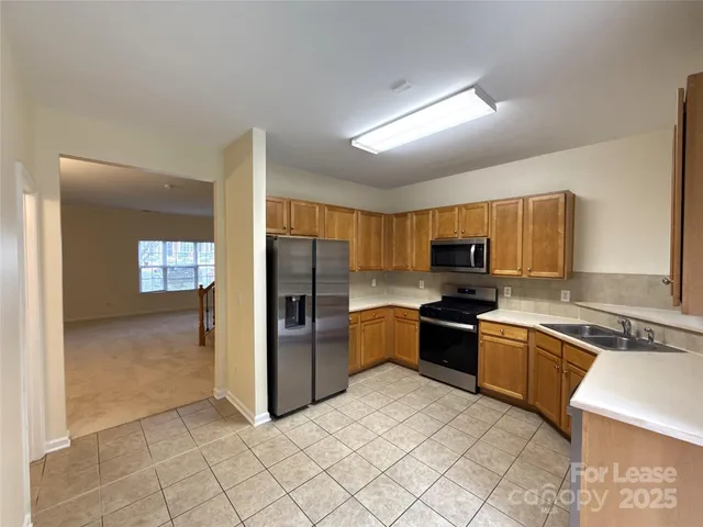 a kitchen with stainless steel appliances granite countertop a refrigerator and a sink