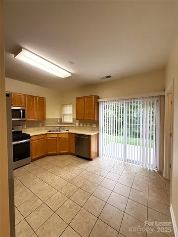 a large kitchen with a large counter top stainless steel appliances and cabinets