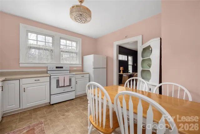 a kitchen that has a stove a table and chairs in it
