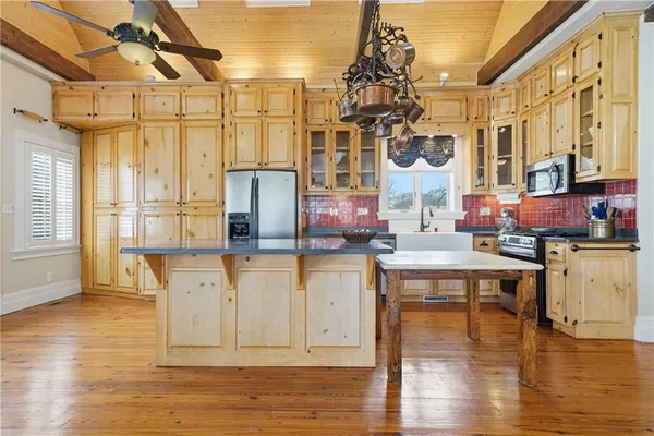 a kitchen with stainless steel appliances granite countertop a white cabinets and wooden floor