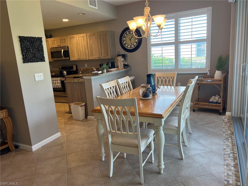 6864 Ascot Drive, Unit 101 Naples, FL 34113 - Photo 12 of 40 a dining room with furniture a window and a kitchen