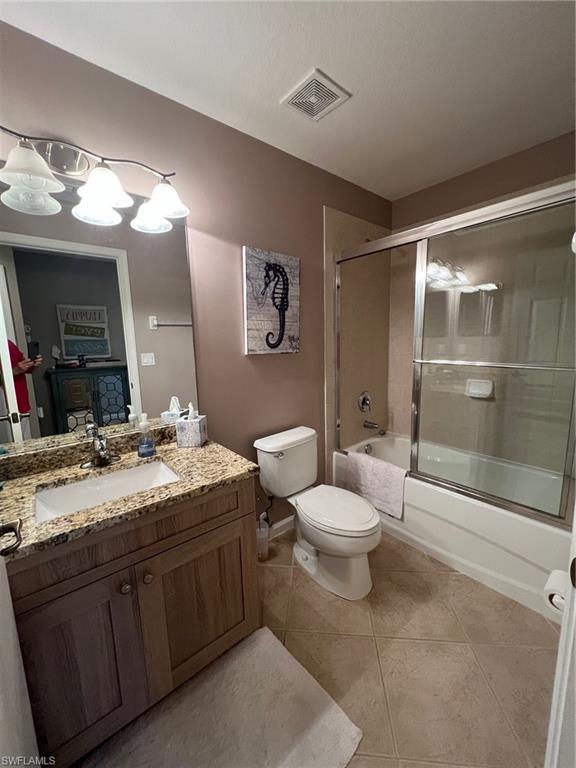6864 Ascot Drive, Unit 101 Naples, FL 34113 - Photo 21 of 40 a bathroom with a granite countertop sink toilet and shower