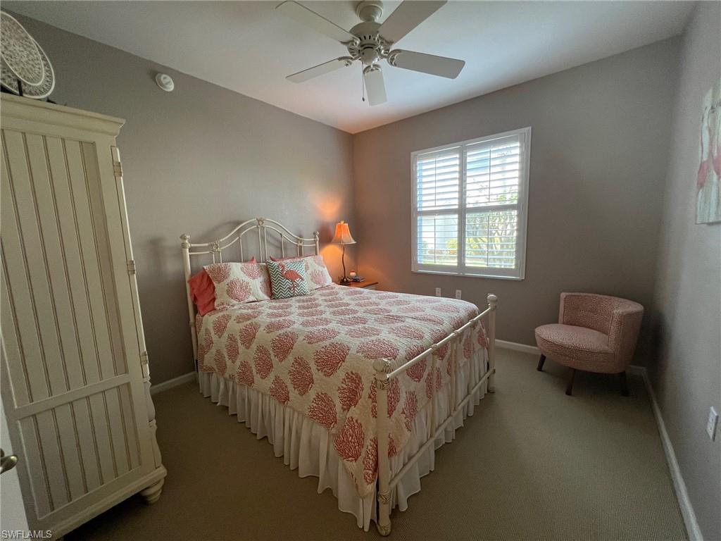 6864 Ascot Drive, Unit 101 Naples, FL 34113 - Photo 22 of 40 a bedroom with a bed and a chandelier