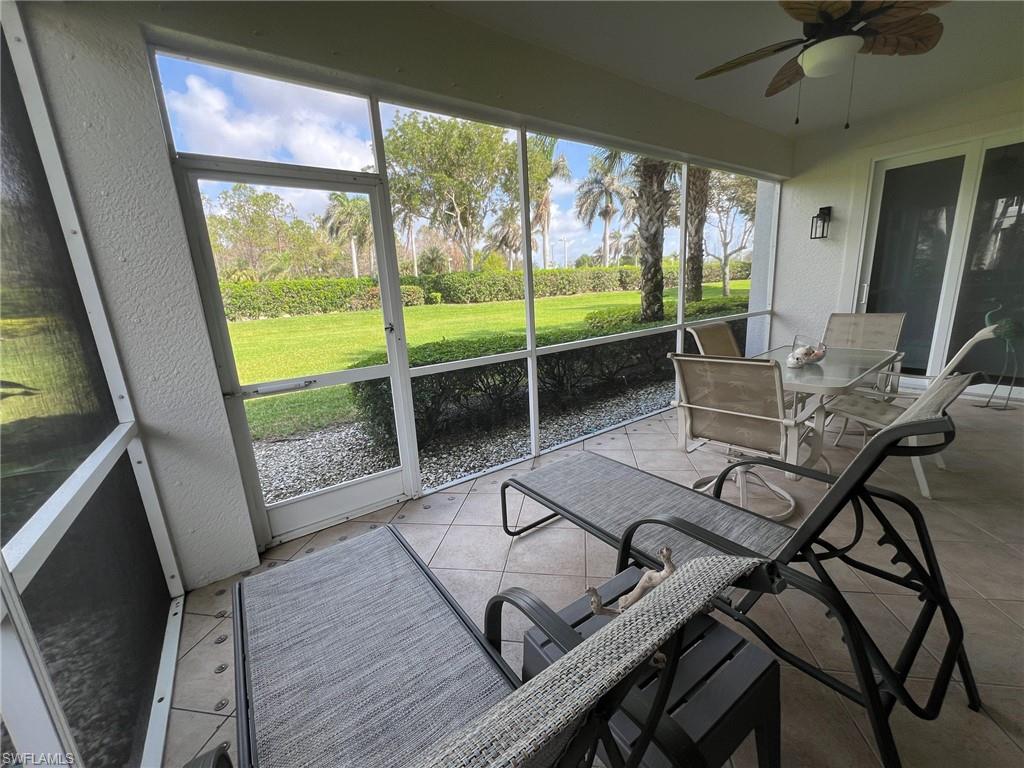 6864 Ascot Drive, Unit 101 Naples, FL 34113 - Photo 25 of 40 a living room with furniture and a floor to ceiling window