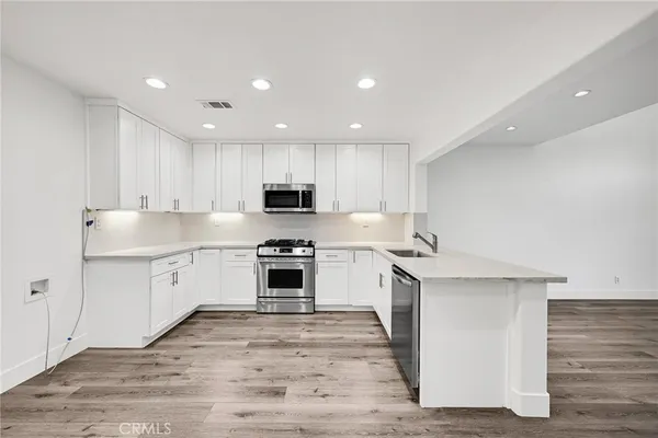 a kitchen with granite countertop white cabinets and white appliances