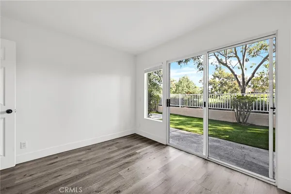 an empty room with wooden floor and door