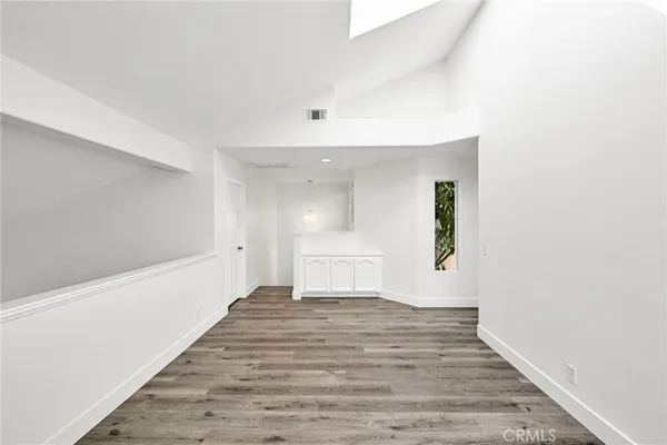 a view of a big room with wooden floor and windows