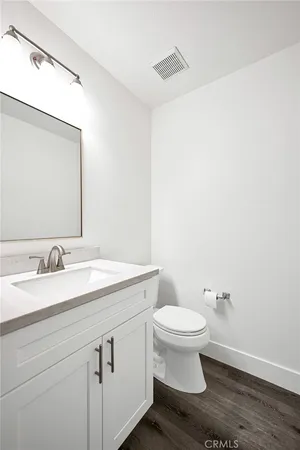 a bathroom with a granite countertop toilet and a sink