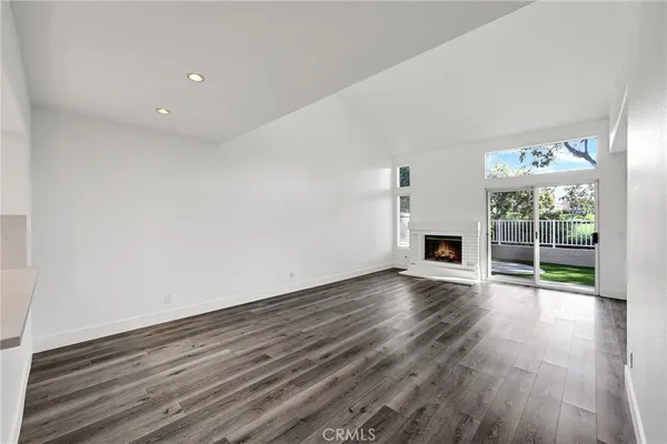 a view of empty room with wooden floor and fireplace