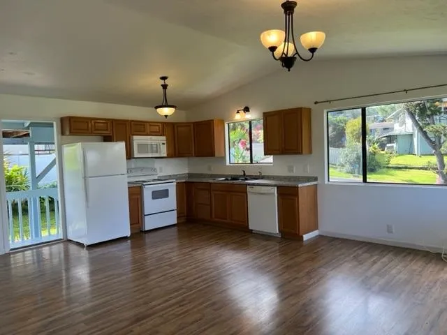 a kitchen with stainless steel appliances granite countertop a refrigerator a stove top oven a sink dishwasher and wooden floor