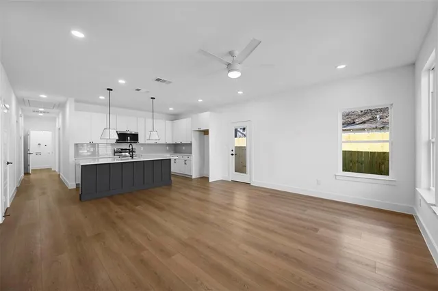 a view of kitchen with kitchen island sink refrigerator and window