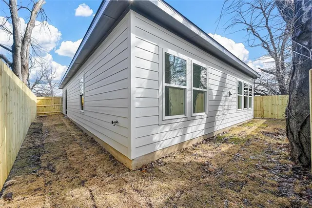 a view of a house with a yard and wooden fence