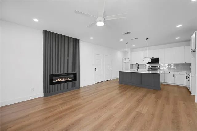 a large kitchen with stainless steel appliances granite countertop a stove a sink and a refrigerator