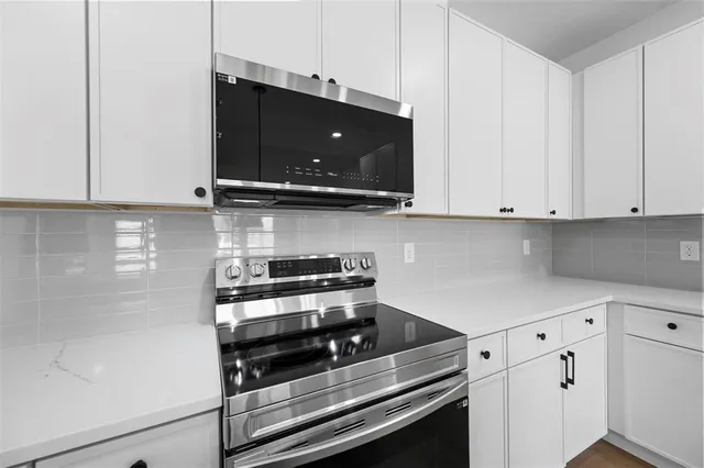 a kitchen with stainless steel appliances a stove and a microwave