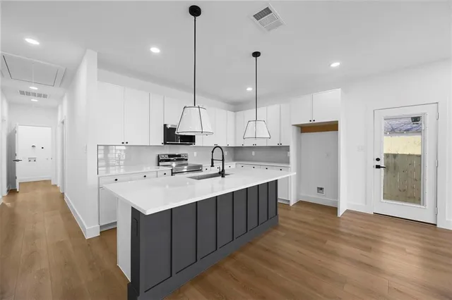 a kitchen with kitchen island a sink stainless steel appliances and cabinets