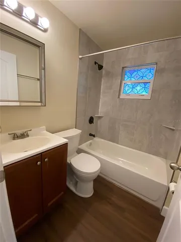 an empty room with wooden floor and natural light