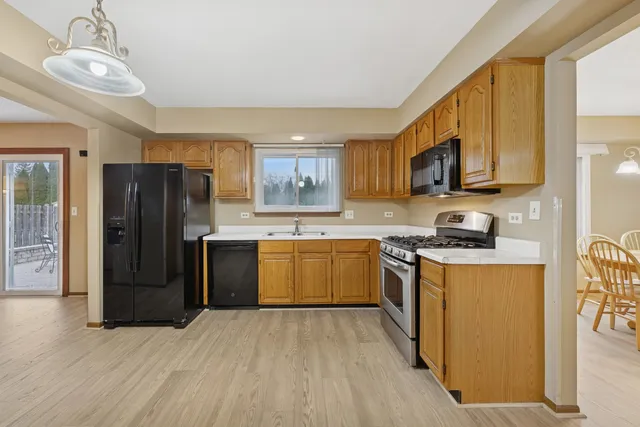 a kitchen with stainless steel appliances granite countertop a refrigerator stove top oven and sink