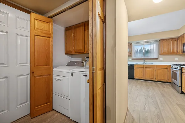 a view of a kitchen with white cabinets and wooden floor