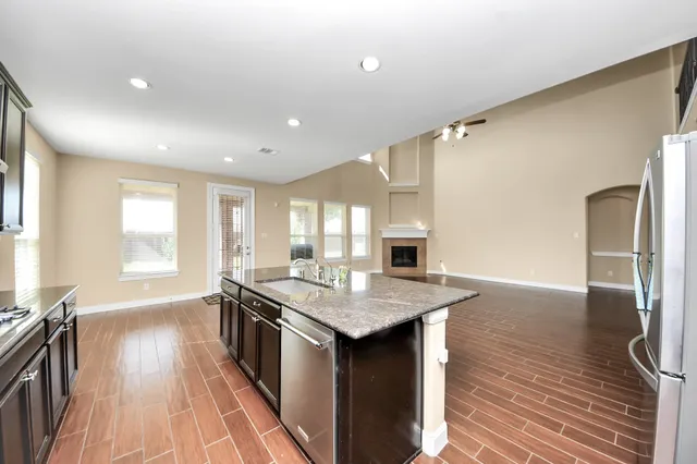 a kitchen with stainless steel appliances granite countertop a sink stove and refrigerator