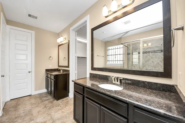 a bathroom with a granite countertop sink and a mirror