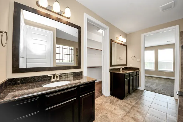 a spacious bathroom with a granite countertop tub sink and mirror