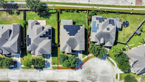 an aerial view of a house with garden space and outdoor seating