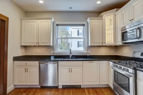 42 Lagrange Street, Unit 1 Boston, MA 02132 - Photo 9 of 29 a kitchen with granite countertop white cabinets and stainless steel appliances