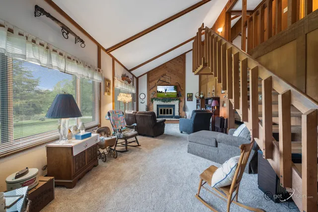 a living room with furniture a flat screen tv and a floor to ceiling window