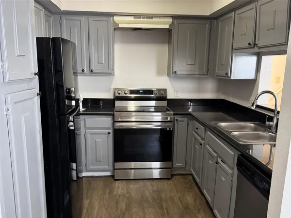 a kitchen with granite countertop a stove and a refrigerator