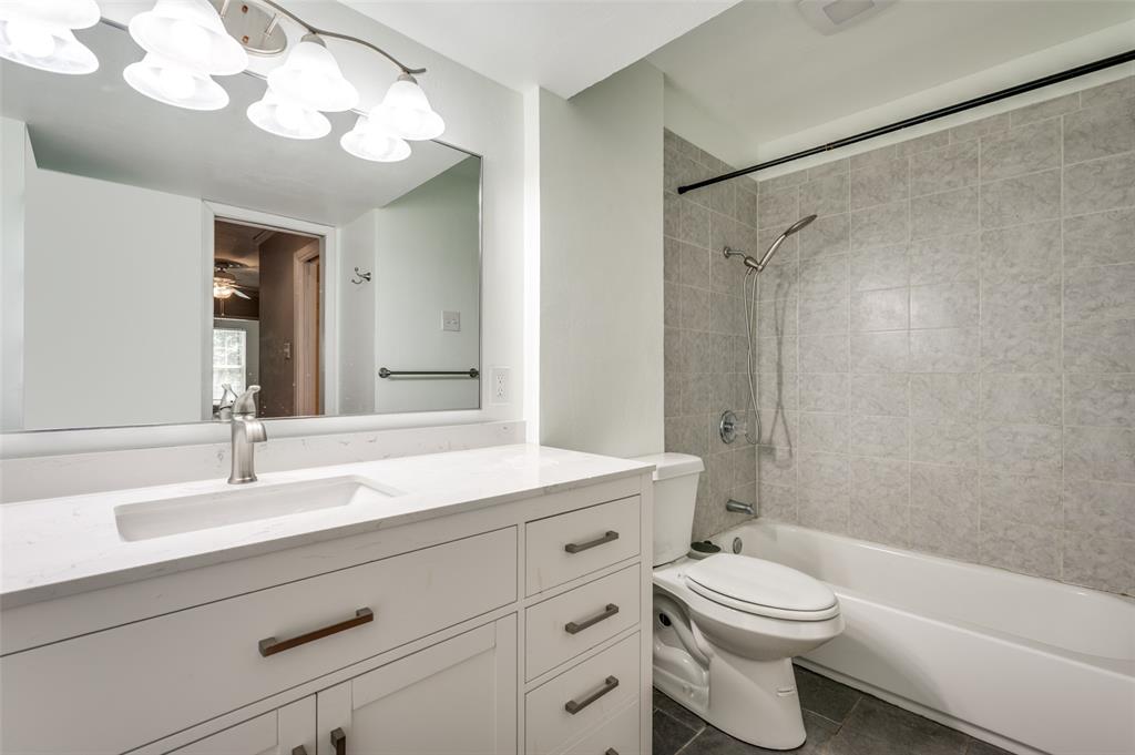 412 Hollyhill Lane Denton, TX 76205 - Photo 12 of 15 a bathroom with a toilet a sink a mirror a bathtub and shower