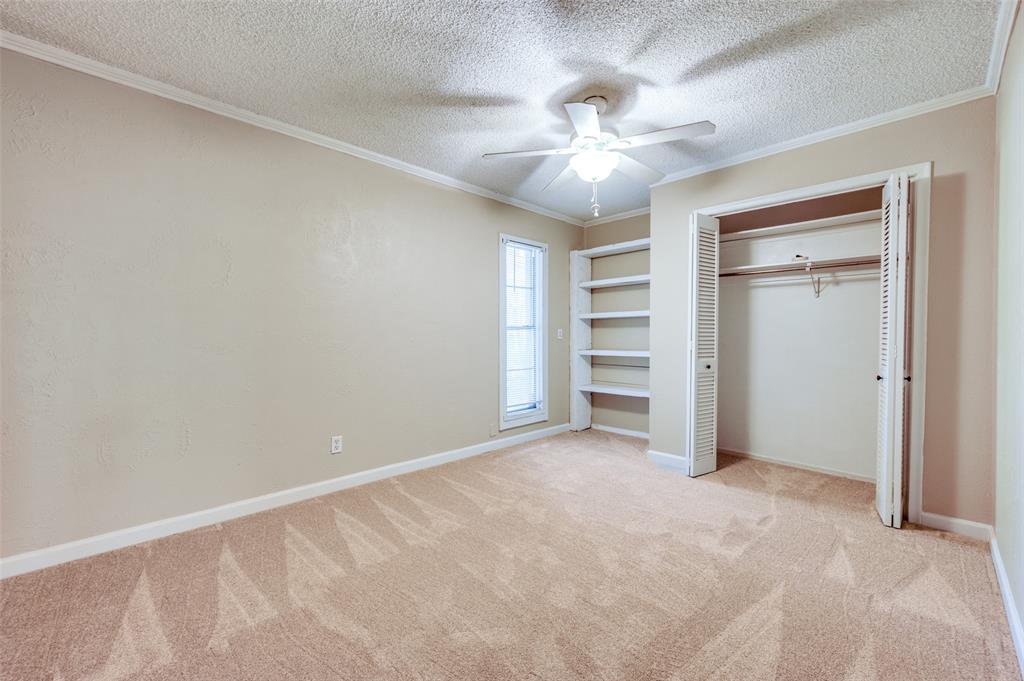 412 Hollyhill Lane Denton, TX 76205 - Photo 9 of 15 an empty room with closet and fan