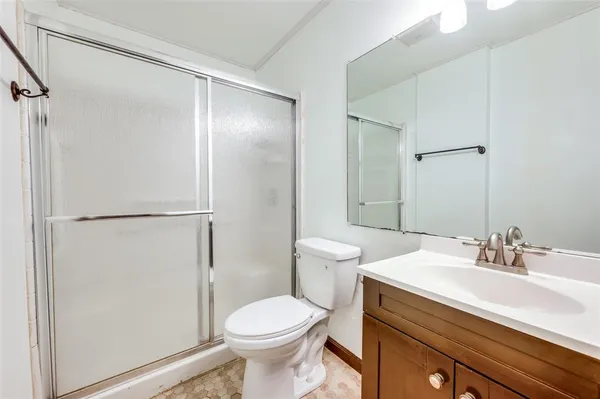 a bathroom with a sink a toilet and shower