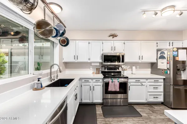 a kitchen with stainless steel appliances granite countertop a sink a stove and a refrigerator