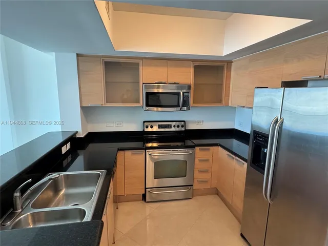 a kitchen with a sink a microwave a stove and refrigerator