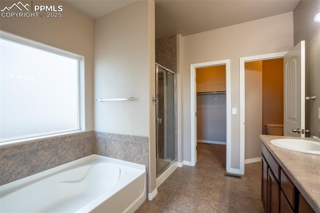 1985 Reed Grass Way Colorado Springs, CO 80915 - Photo 13 of 37 a bathroom with a granite countertop tub sink and mirror